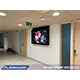 An anti-ligature TV enclosure protects a display within a youth facility corridor