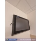 A behavioral health TV enclosure installed on a hospital patient room wall