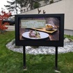 Outdoor TV enclosure on a stand in front of a restaurant