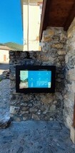 An outdoor TV enclosure wall mounted on a decorative wall